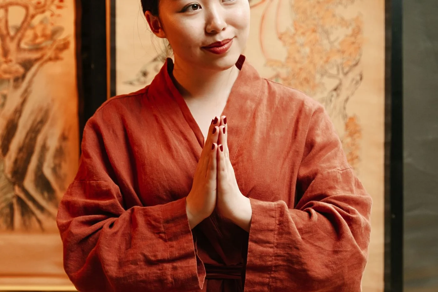 穿著紅色袍子的亞洲女性進行寧靜茶道儀式,呼應專業茶學課程的教學場景 | A woman in red robe performing a tranquil tea ceremony, echoing the teaching scene of professional tea courses