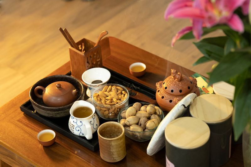精美擺放的茶具與點心放在木制茶盤上，展現完整茶具組合 | Exquisitely arranged teaware and pastries on wooden tray showcasing complete tea set
